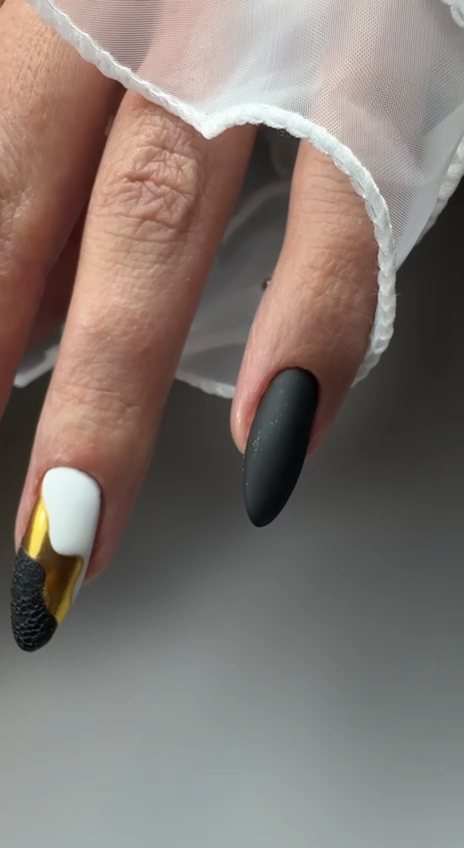 Matte black almond gel nails with a white, gold foil and black sugar-texture accent nail at Paradisse Studio, Richmond Hill
