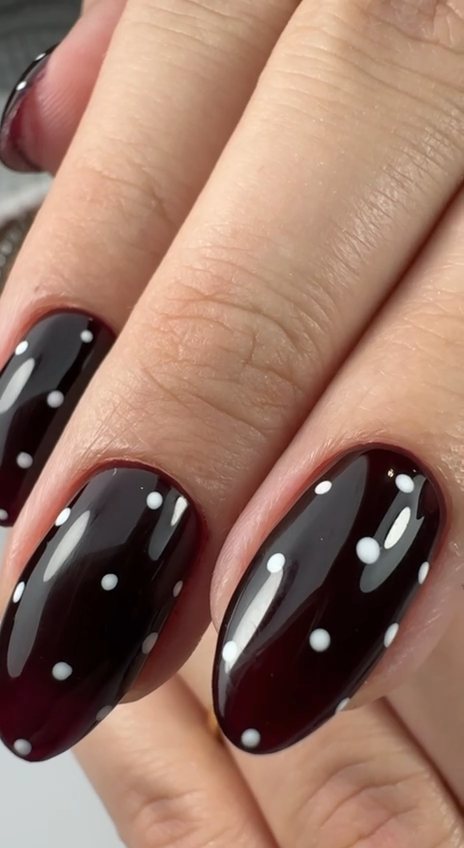 Deep burgundy almond gel nails with white polka dots at Paradisse Studio, Richmond Hill