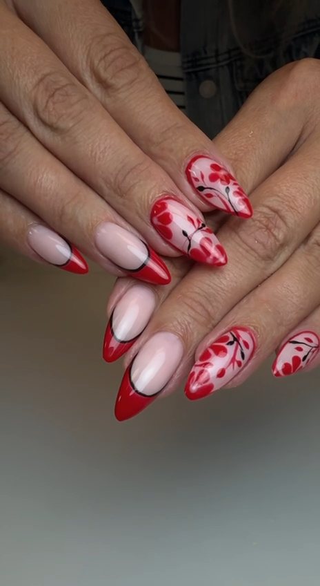 Stiletto nails with red French tips outlined in black and hand-painted red floral vines at Paradisse Studio, Richmond Hill