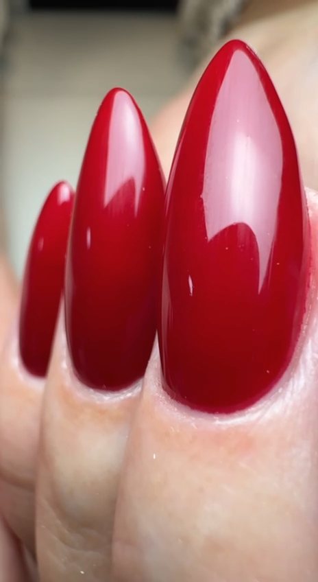 Close-up of glossy classic red gel stiletto nails at Paradisse Studio, Richmond Hill